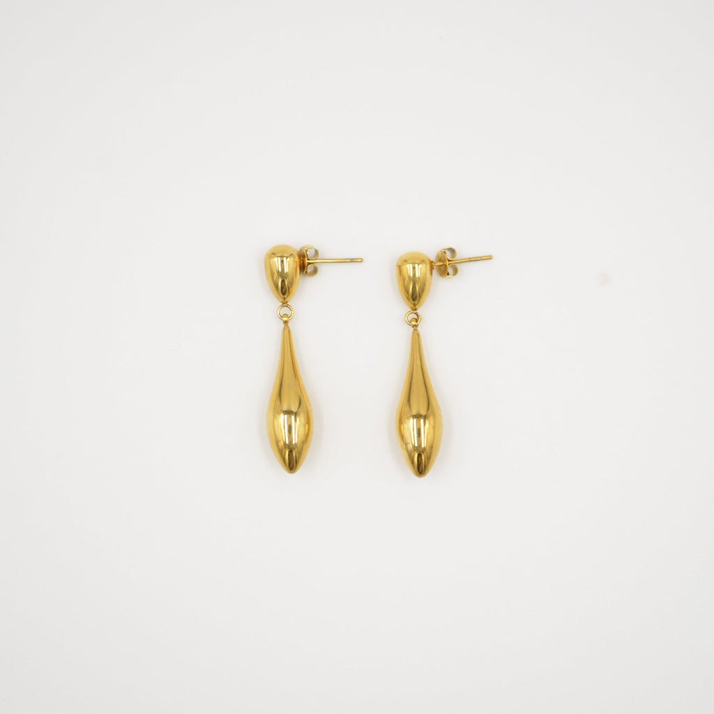 Pair of gold earrings on a light gray background